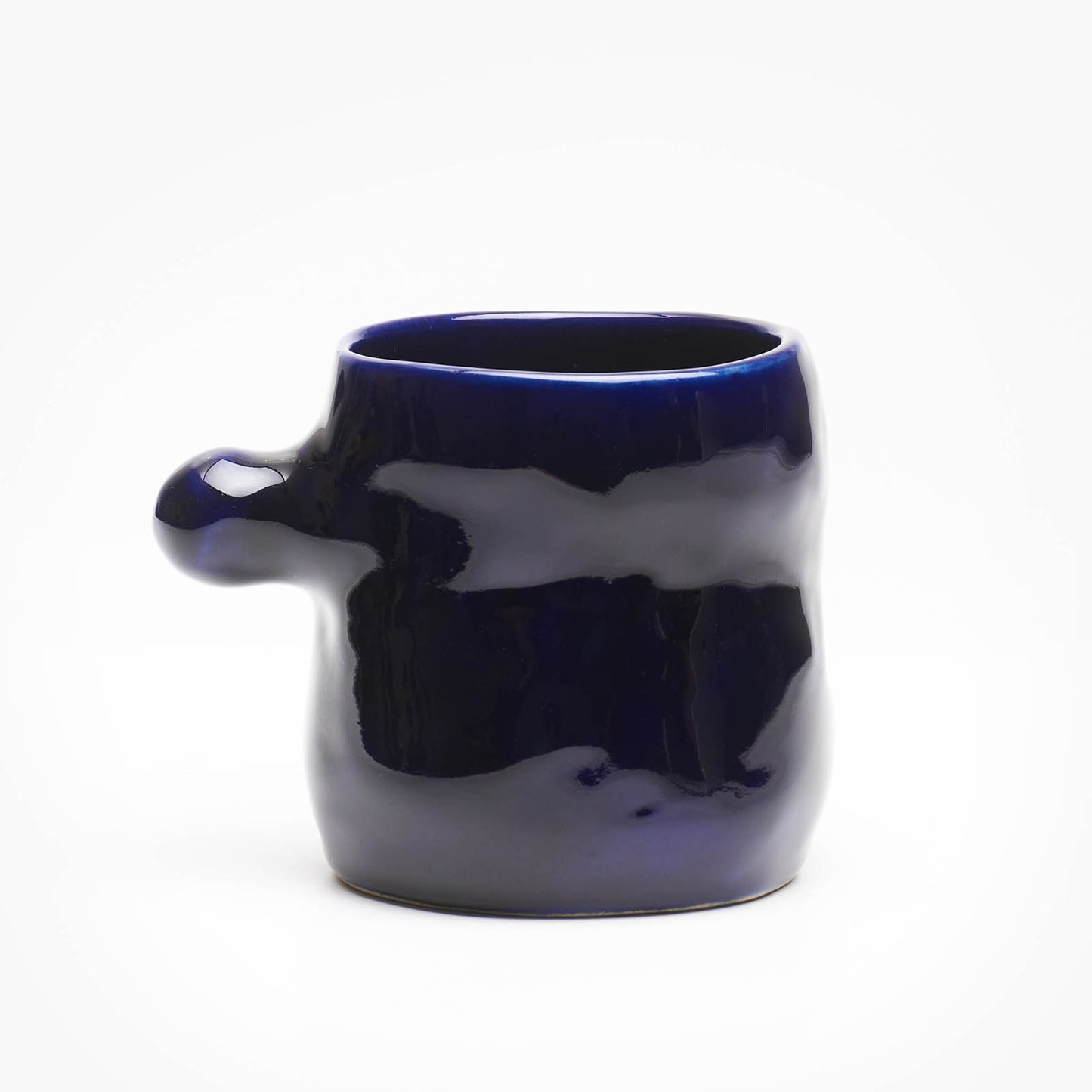 A hand-built ceramic mug in ocean blue glaze, featuring a knob-shaped handle reminiscent of underwater kelp leaves.