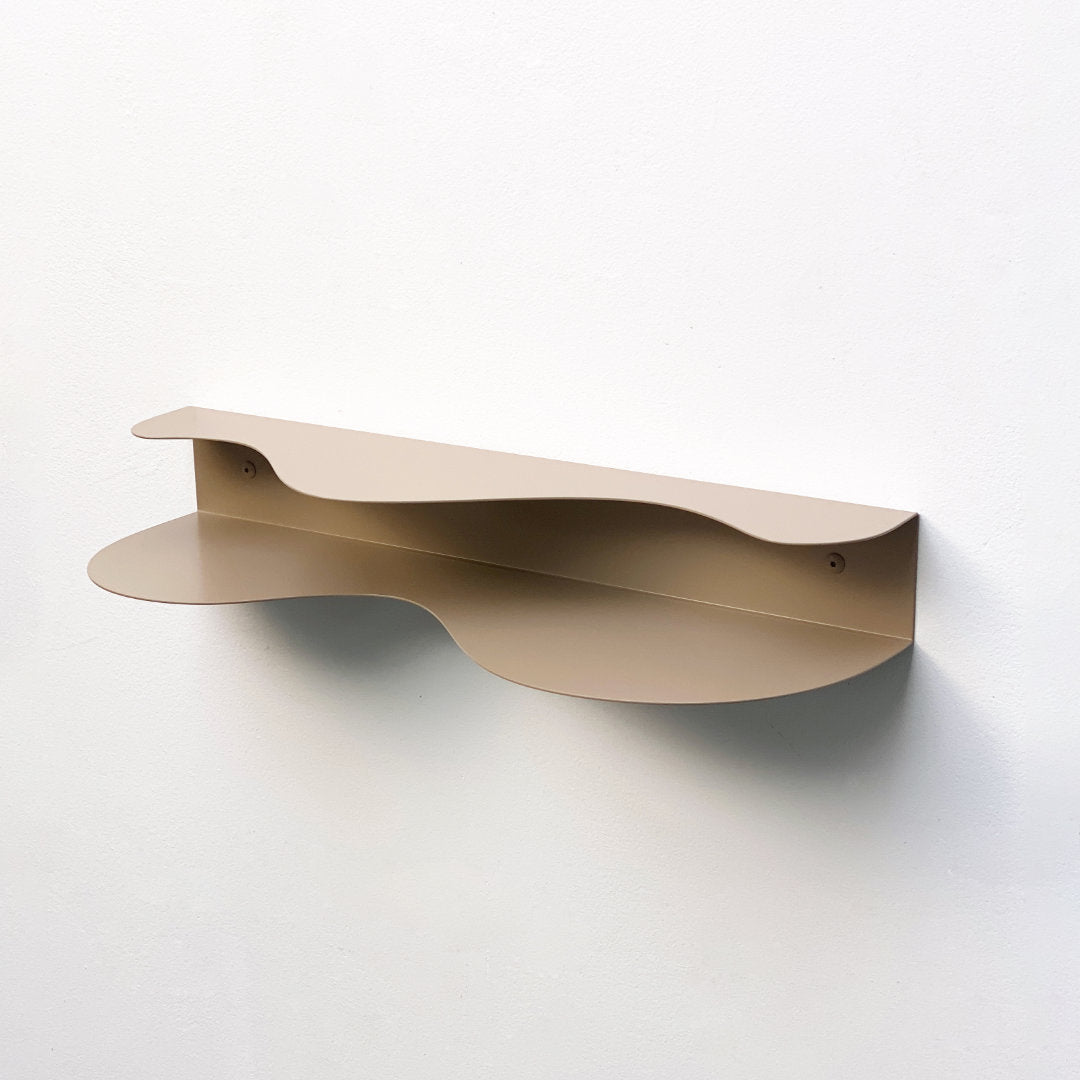 blob shaped curvy shelf in beige against a white wall