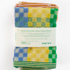 Odds and Ends multi cloth, checkered check design in primary and bright colours with a striped edge by Foekje Fleur,  limited edition number 18, pack of 2, seen here on a white background, photographed with the packaging label, from the back